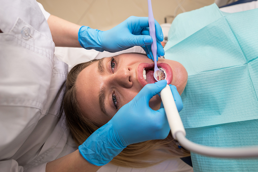 A Young Girl In A Dental Chair Fills A Tooth. Visiting An Orthod