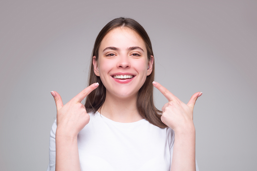 Beautiful Woman Pointing To Teeth. Beautiful Smile With White Te