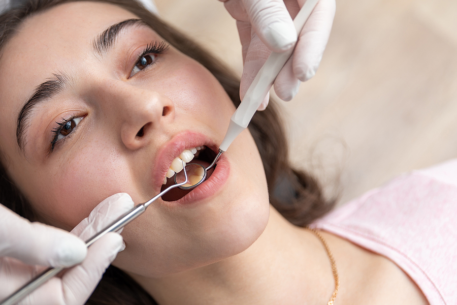 Dental Check Up In Dential Clinic. Dentist Examining Patient Tee