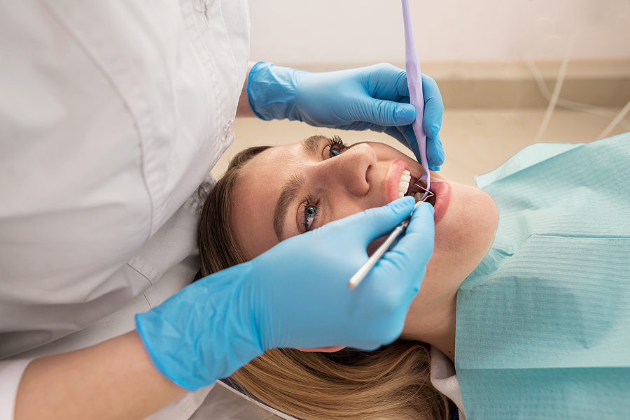 Dentist-hygienist Conducts A Teeth Cleaning Procedure For A Girl