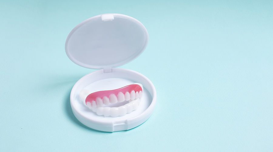 Full Removable Plastic Denture In Box On A Blue Background. Two