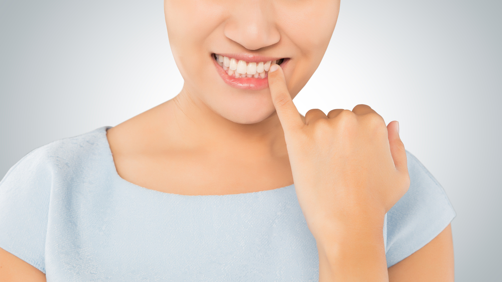 Woman,Looking,In,Mirror,And,Checking,Teeth